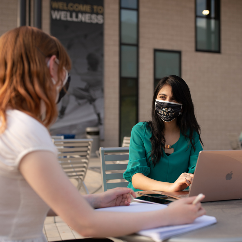 2 students talking in courtyard