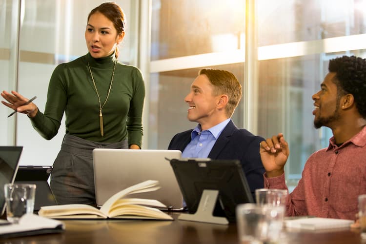 Professional people listening to a woman give a presentation