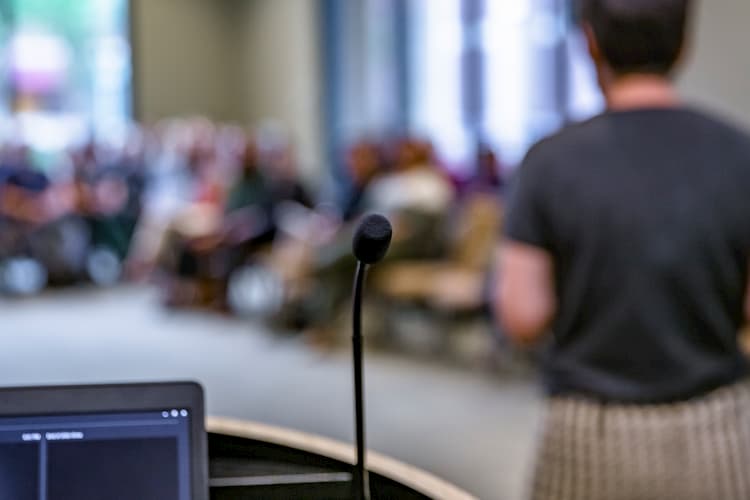 Picture of a microphone with a presentation going on in the background