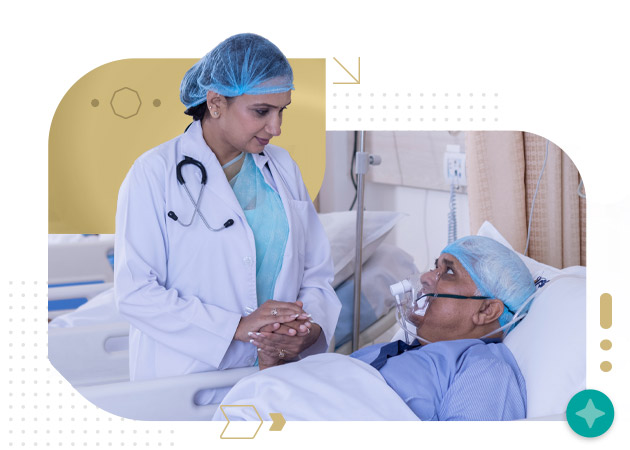 Female nurse holding hands of senior patient in oxygen mask in hospital