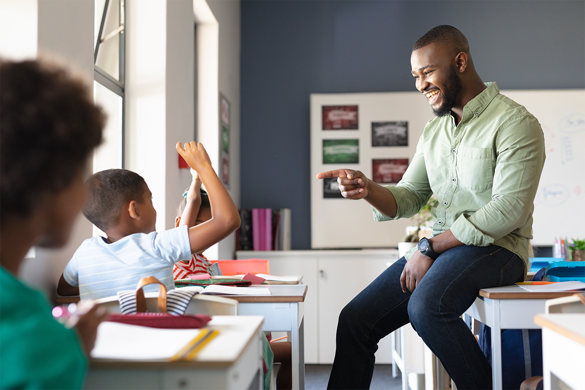 Teacher interacting with a young student in a classroom.