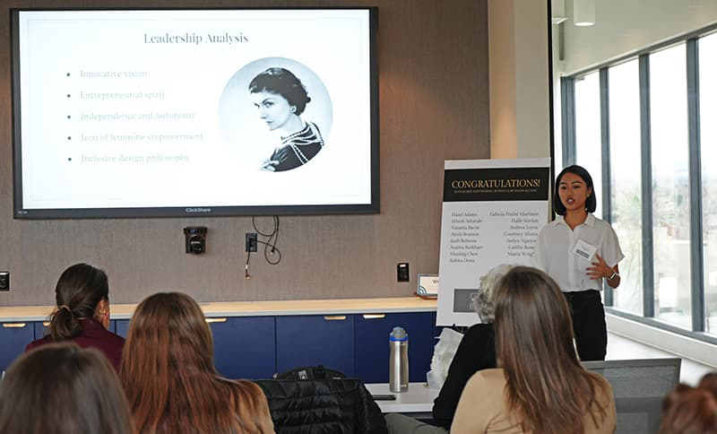 Empowering Women in Business student presenting in front of a classroom.