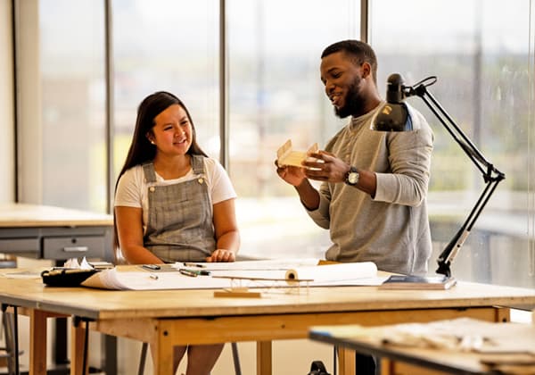 Two students discussing an architecture project