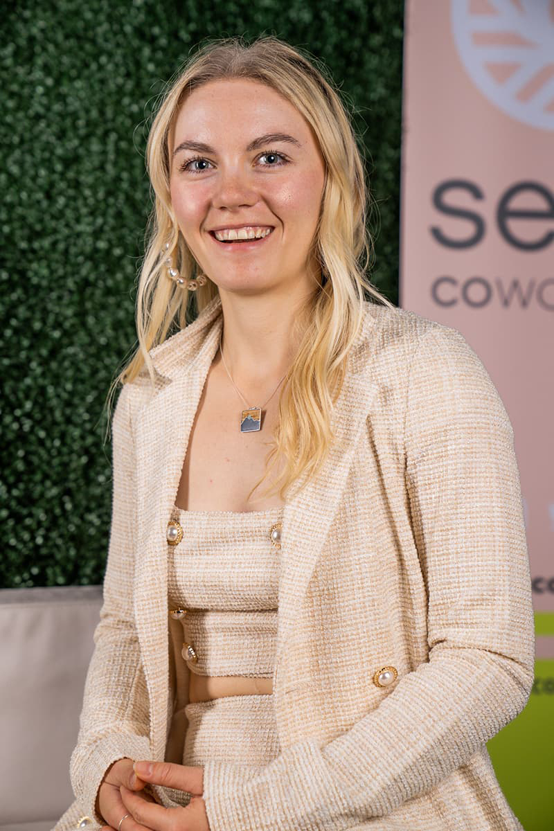 Rachelle Pulver in a light beige suite and long blonde hair, smiling with her teeth.