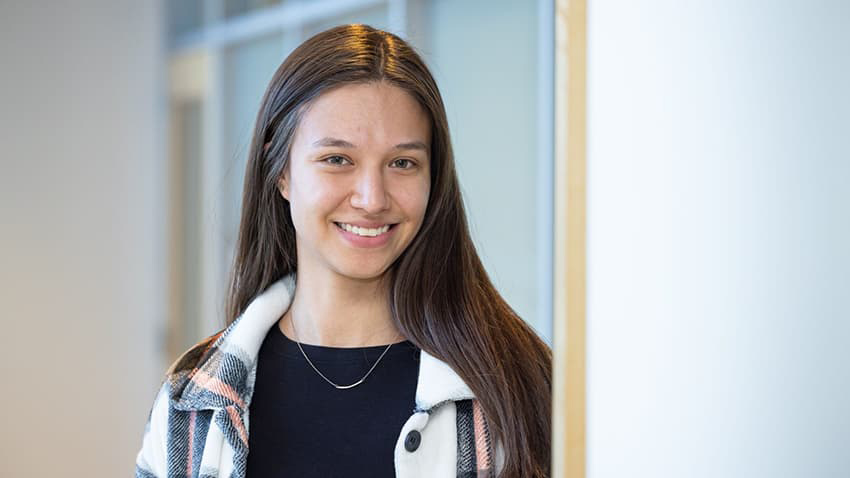 CU Denver student Sam Carrillo standing in a doorway smiling.