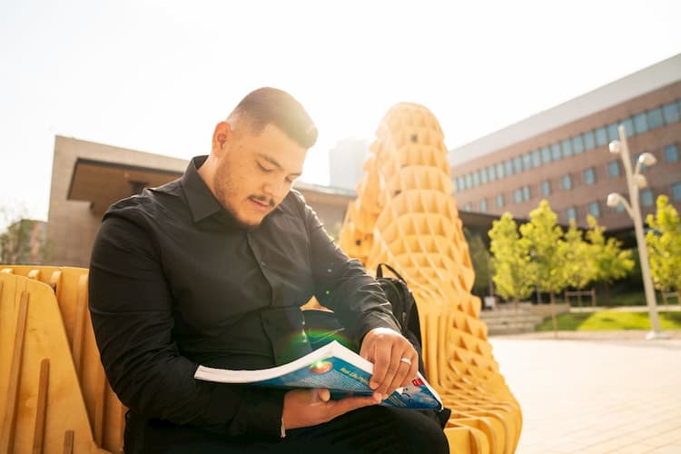 Student reading in front of Wellness Center