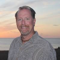 headshot of Steve Sutter from the shoulders up in front of ocean sunset smiling