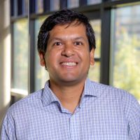 Headshot of Ashis Biswas in business casual shirt smiling