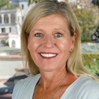 Headshot of Jodi Waterhouse from the shoulders up smiling in business casual top.