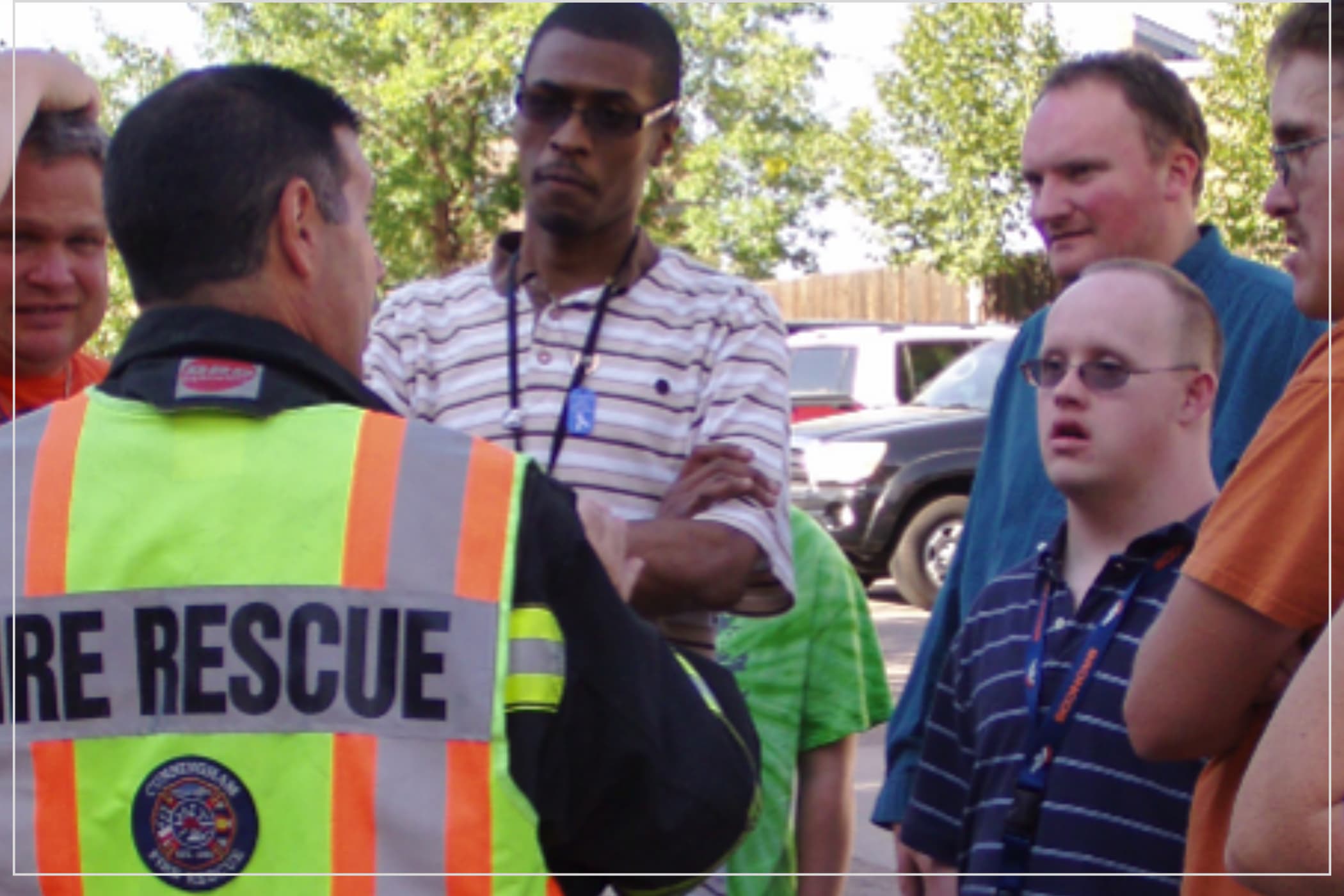 A group of people with developmental disabilities listens to a fire rescue trainer