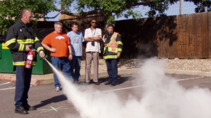 A firefighter shows how to use a fire extinguisher