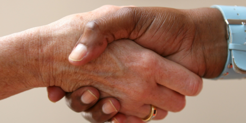 Close-up of two hands shaking.